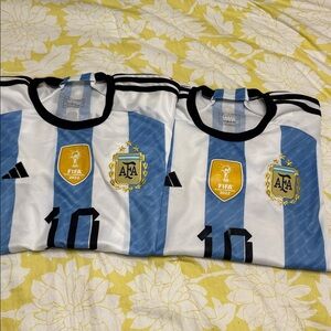 A pair of Adidas Blue and White Striped Jersey Messi World Cup 22